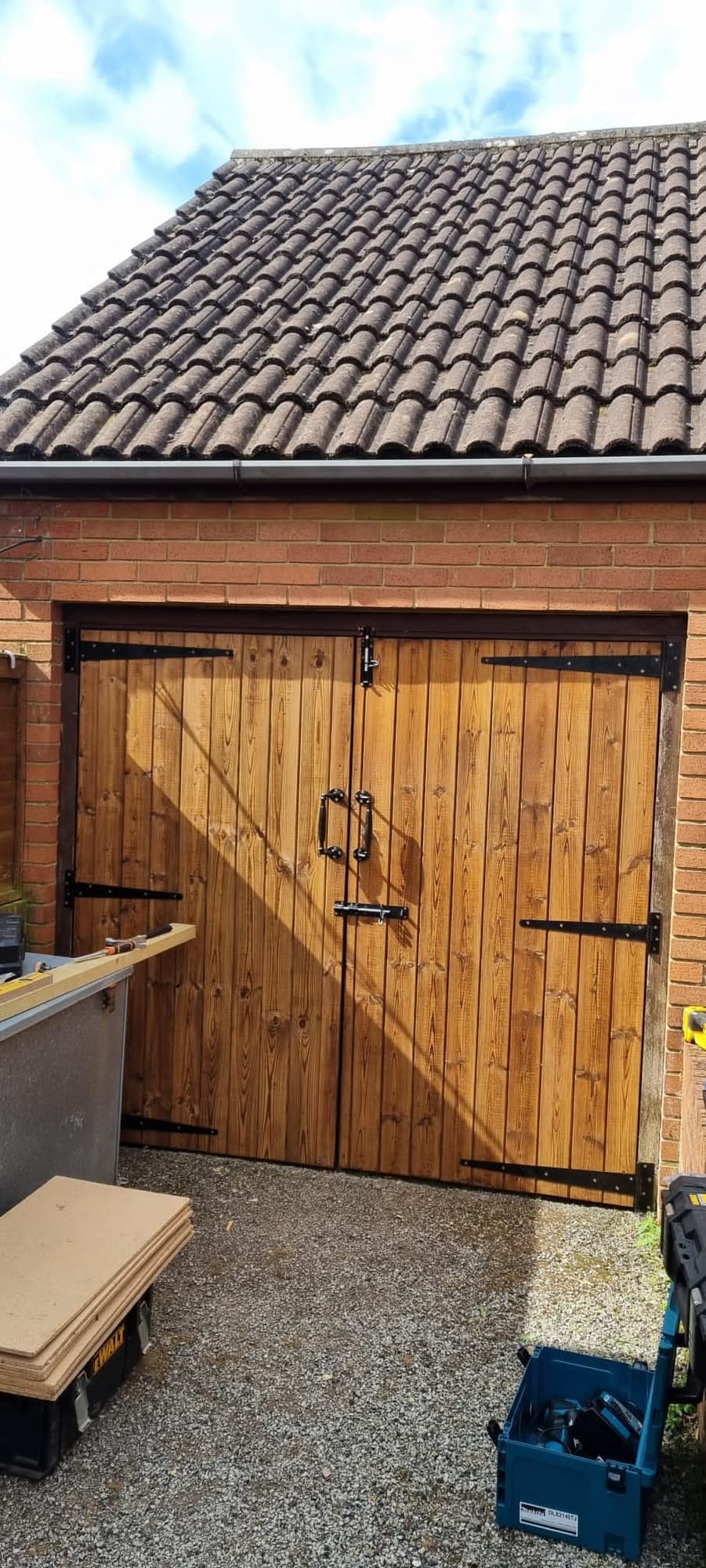 Pair of new wooden doors fitted to a brick garage